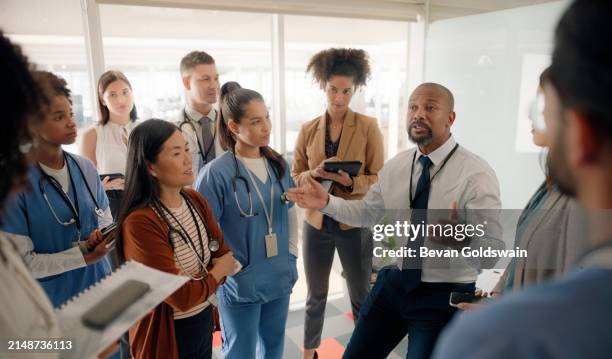 boardroom, discussion and executive talking to staff in hospital for healthcare of patients. man, training and mentor of employees or nurses and tablets for notes of speech by leader in medical field - nurse leader stock pictures, royalty-free photos & images