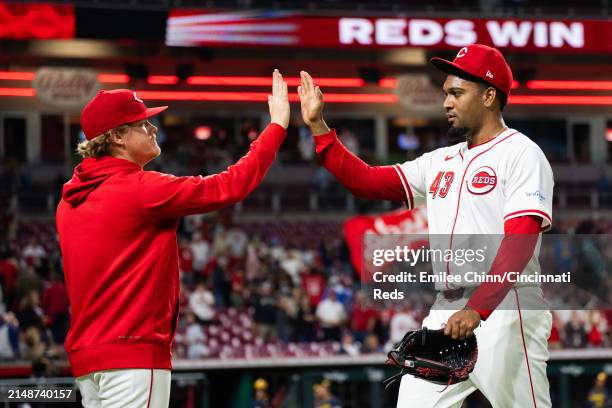 Alexis Diaz of the Cincinnati Reds high fives Andrew Abbott after a win during a game against the Milwaukee Brewers at Great American Ball Park on...