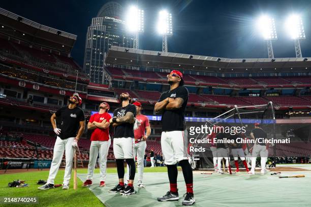 Santiago Espinal, Jonathan India, Tyler Stephenson and Bubba Thompson of the Cincinnati Reds watch the Solar Eclipse before a game against the...