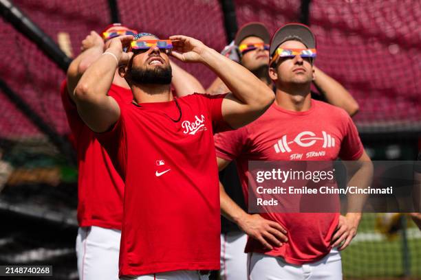 Nick Martini and Spencer Steer of the Cincinnati Reds watch the Solar Eclipse before a game against the Milwaukee Brewers at Great American Ball Park...