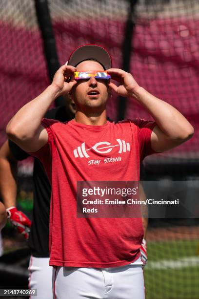 Spencer Steer of the Cincinnati Reds watches the Solar Eclipse before a game against the Milwaukee Brewers at Great American Ball Park on April 08,...