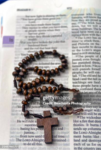 high angle view of a wooden rosary on a bible - gebetskette stock-fotos und bilder