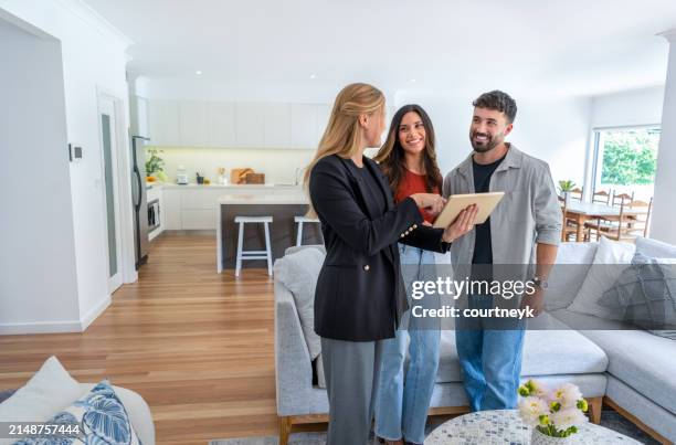 real estate agent or architect showing a couple a new home. - vender fotografías e imágenes de stock