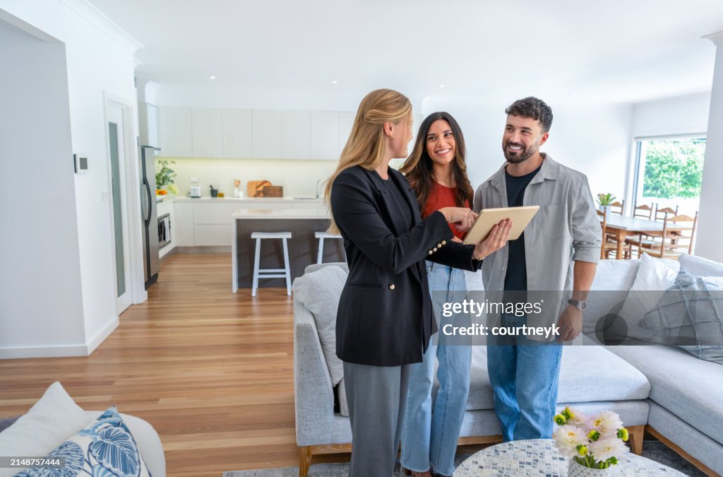 Real estate agent or architect showing a couple a new home.