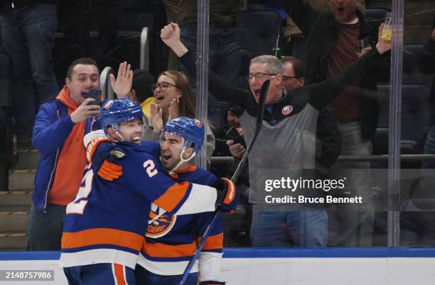 Kyle Palmieri of the New York Islanders celebrates his game-winning overtime goal against the Montreal Canadiens and is joined by Mike Reilly at UBS...