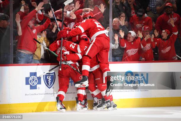 Lucas Raymond of the Detroit Red Wings celebrates his game winning overtime goal with teammates to defeat the Montreal Canadiens 5-4 at Little...