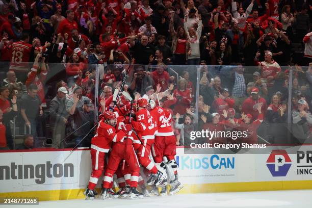 Lucas Raymond of the Detroit Red Wings celebrates his game winning overtime goal with teammates to defeat the Montreal Canadiens 5-4 at Little...