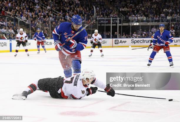 Brady Tkachuk of the Ottawa Senators is checked by K'Andre Miller of the New York Rangers during the third period at Madison Square Garden on April...