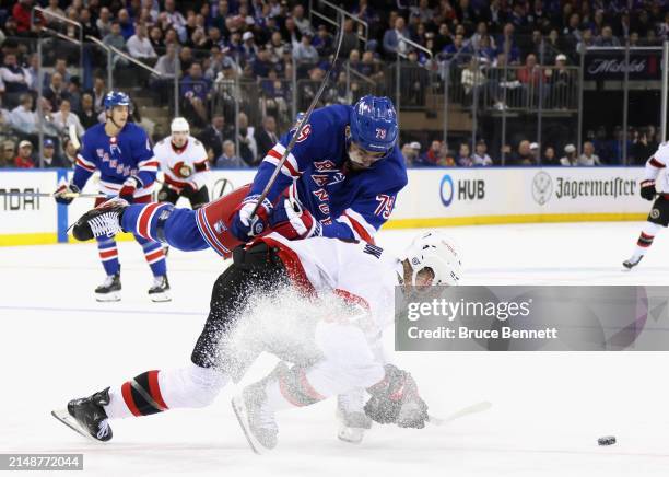 Brady Tkachuk of the Ottawa Senators is checked by K'Andre Miller of the New York Rangers during the third period at Madison Square Garden on April...