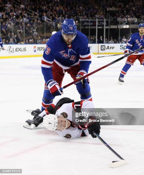 Brady Tkachuk of the Ottawa Senators is checked by K'Andre Miller of the New York Rangers during the third period at Madison Square Garden on April...