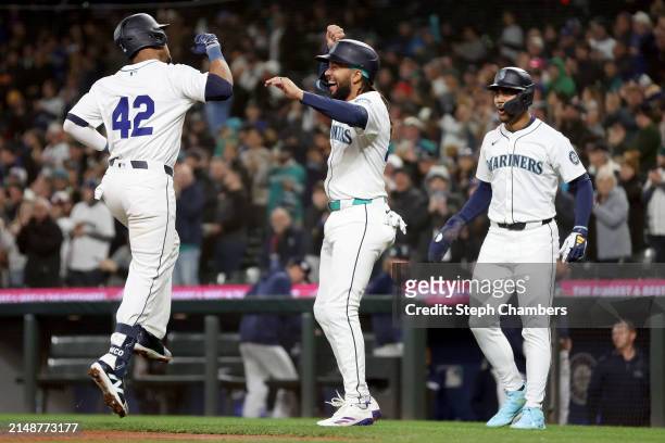 Jorge Polanco of the Seattle Mariners reacts after his three run home run with J.P. Crawford and Julio Rodriguez during the first inning against the...