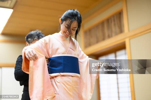 foreign visitors enjoying the cultural experience of being dressed in a japanese kimono. - kimono photos et images de collection