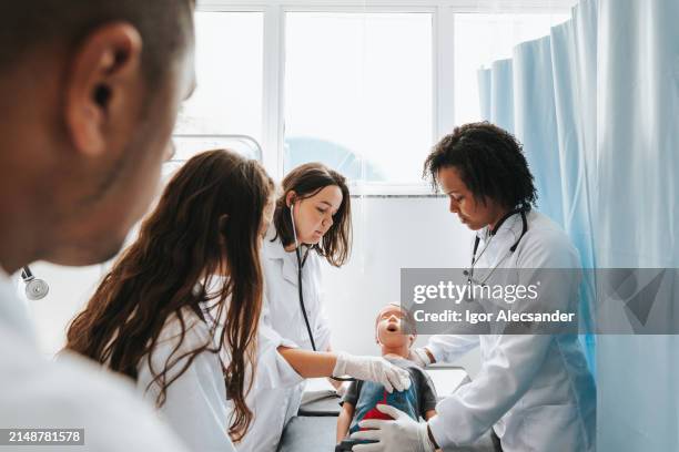 medical students in practical class with doll in the ward - realistic male mannequin stock pictures, royalty-free photos & images