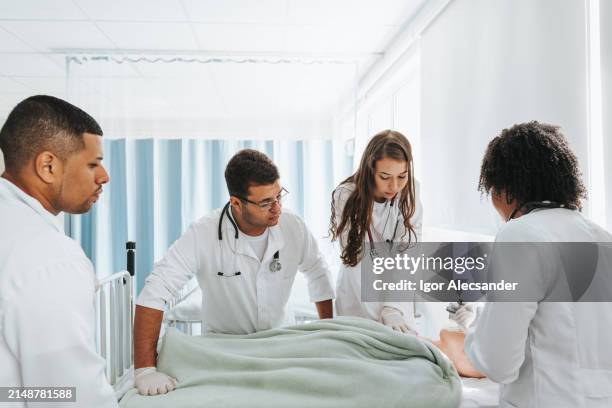 medizinstudenten im praktischen unterricht mit puppe auf der station - medizinische fakultät stock-fotos und bilder