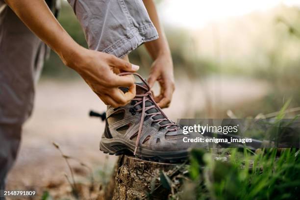 tying shoelaces on shoes in nature! - wanderschuhe stock-fotos und bilder