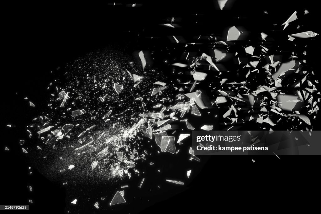 Broken Glass on Black Background shows the abstract texture of the shattered glass in great detail. The image is perfect for use in backgrounds, textures, or abstract art projects.