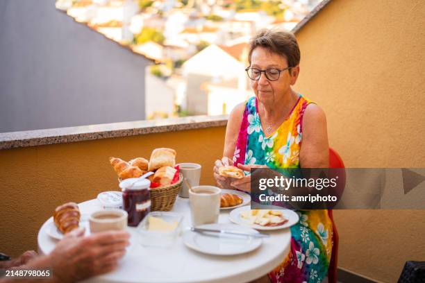 pareja de ancianos desayunando en la mañana de verano en la terraza - viaje barato fotografías e imágenes de stock