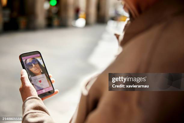 smiling man looking at dating app message, it’s a match - dating app stock pictures, royalty-free photos & images