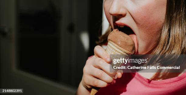 close-up of a little girl licking a chocolate ice cream - licking stock pictures, royalty-free photos & images