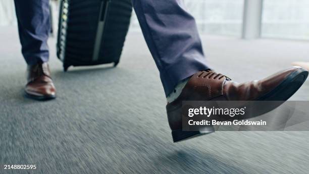 suitcase, travel and feet of businessman at airport for journey, trip or immigration at company. luggage, legs and professional person with commute for international business, corporate and employee - stappen stockfoto's en -beelden