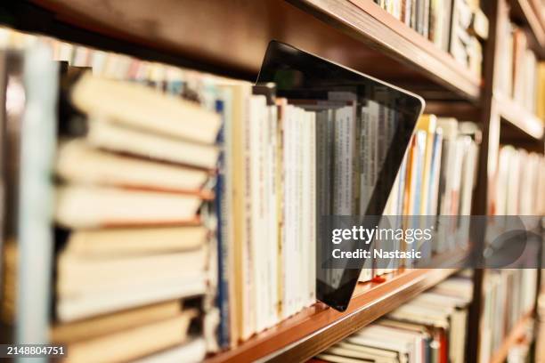 vista della tavoletta digitale sullo scaffale - lettore di libri elettronici foto e immagini stock