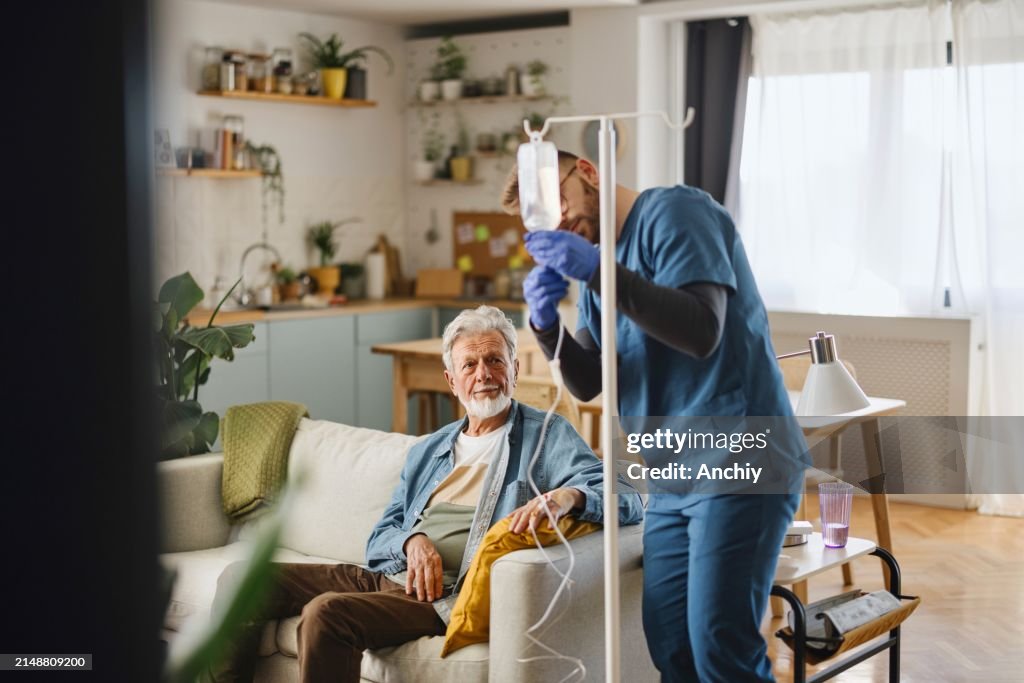 Caregiver di sesso maschile che somministra un'infusione al paziente