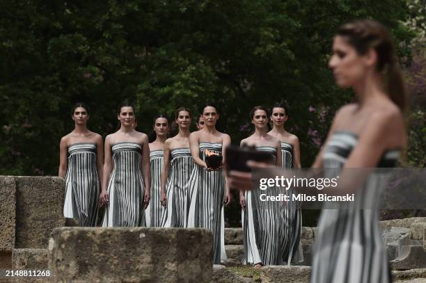 Greek actress Mary Mina, playing the role of the High Priestess, carries the Olympic Flame during the flame lighting ceremony for the Paris 2024...