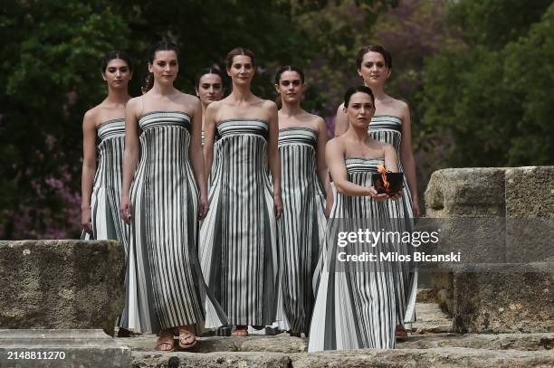 Greek actress Mary Mina, playing the role of the High Priestess, carries the Olympic Flame during the flame lighting ceremony for the Paris 2024...