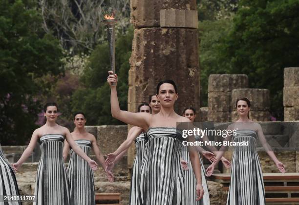 Greek actress Mary Mina, playing the role of the High Priestess, holds the torch during the flame lighting ceremony for the Paris 2024 Summer...