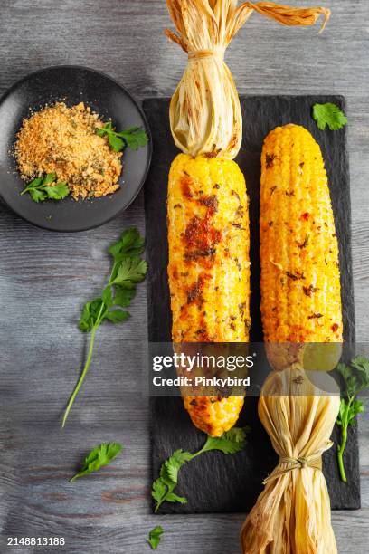 grilled corn cob with herbs and cheese. corn on the cob. corn. sweet yellow corn. fresh corn with spice. barbecue and grilled corn with cheese. - roasted corn stock pictures, royalty-free photos & images