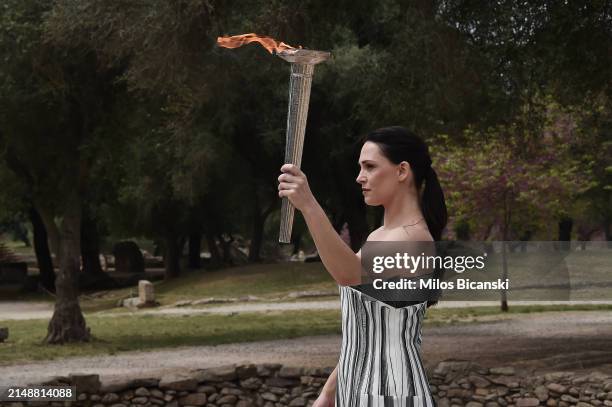 Greek actress Mary Mina, playing the role of the High Priestess, carries the torch during the flame lighting ceremony for the Paris 2024 Summer...