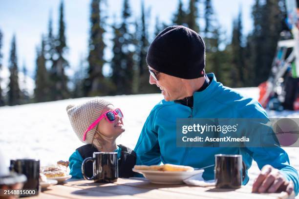 ski family enjoy snack outdoors - family skiing stock pictures, royalty-free photos & images
