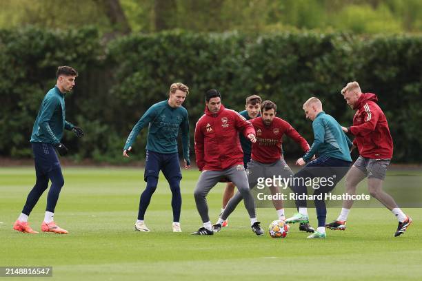 Mikel Arteta, Manager of Arsenal, participates in a training session alongside his players Kai Havertz, Martin Odegaard and Oleksandr Zinchenko at...