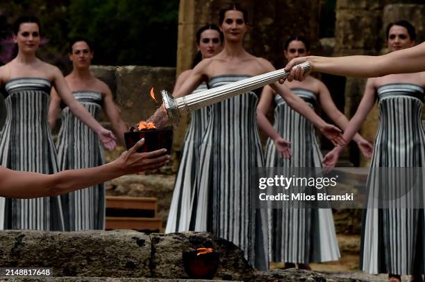 Greek actress Mary Mina, playing the role of the High Priestess, holds the torch during the flame lighting ceremony for the Paris 2024 Summer...