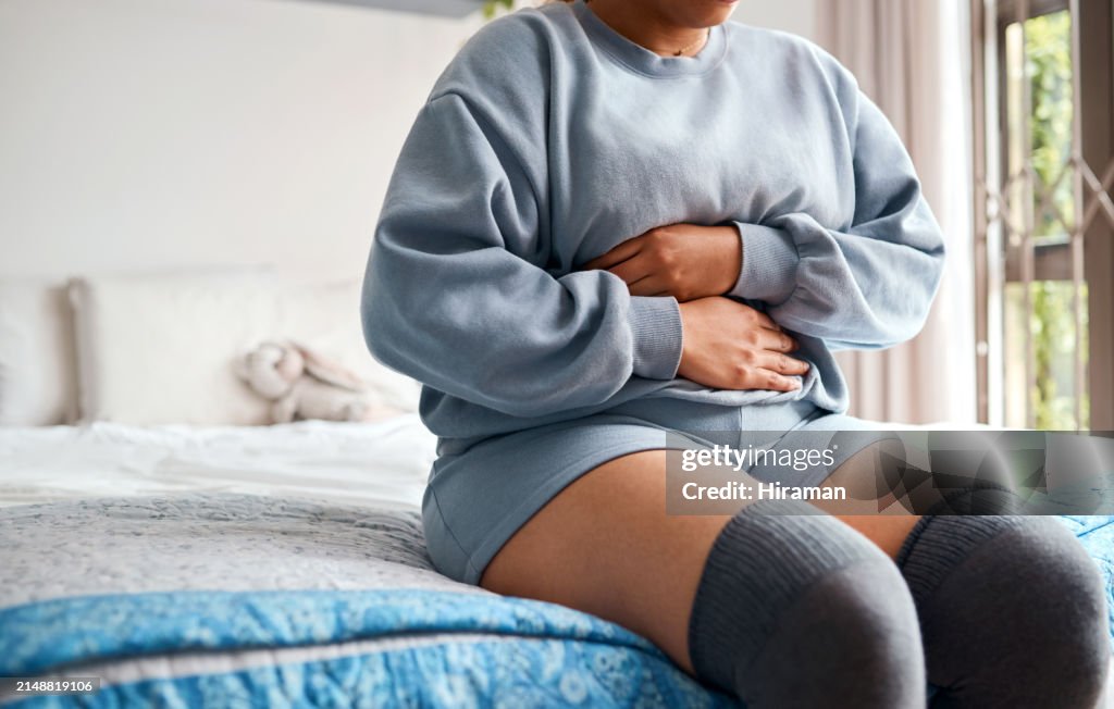 Persona, mal di stomaco o problemi di digestione in camera da letto con stitichezza, gas addominale o disturbi mestruali. Donna, salute dell'intestino o malato di mal di pancia, endometriosi o crampi da sindrome dell'intestino irritabile a letto a casa