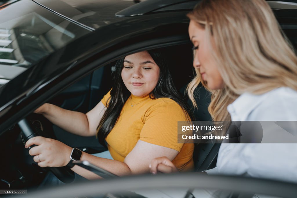 Car saleswoman using digital tablet