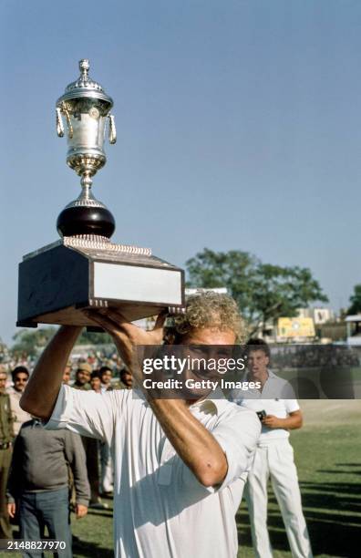 England captain David Gower celebrates with the series trophy after the 5th and final Test Match against India ends in a draw and England win the...