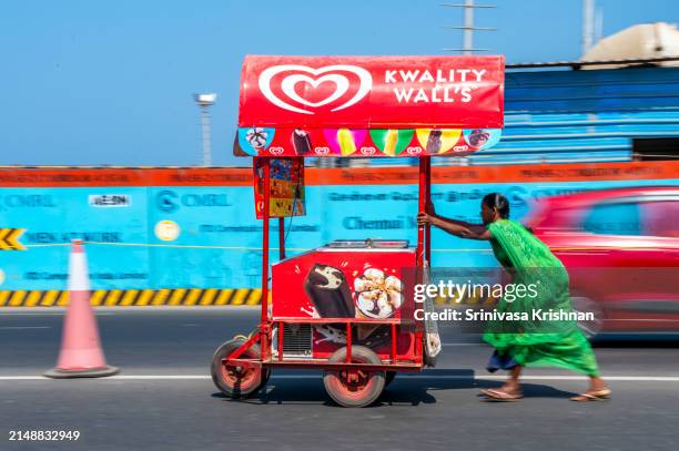 woman ice-cream seller going for work on a peak summer afternoon - chennai stock pictures, royalty-free photos & images