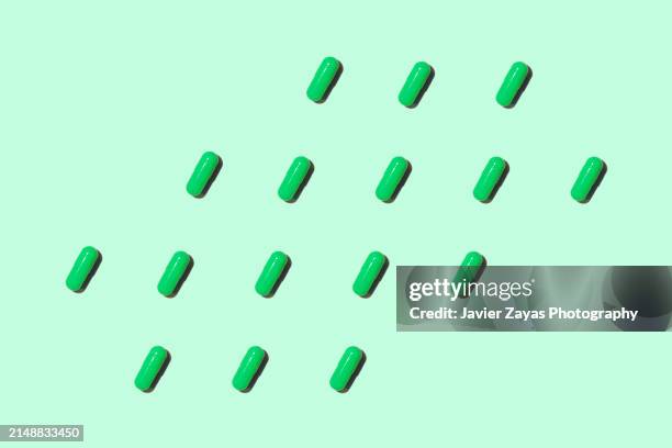 green pills isolated on green background - highly trafficked stock pictures, royalty-free photos & images