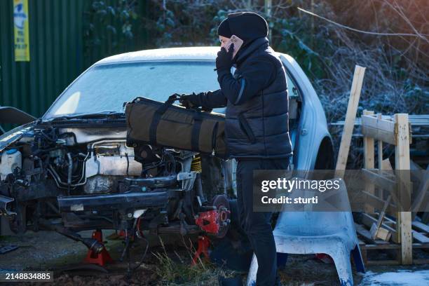 hombre sospechoso en un depósito de chatarra - mafia fotografías e imágenes de stock