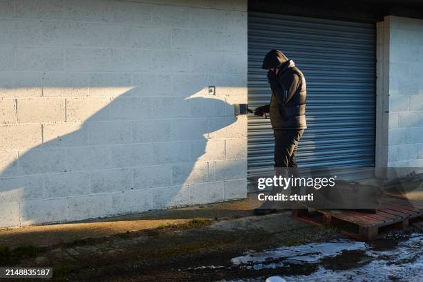 suspicious man at storage facility - suspicion stock pictures, royalty-free photos & images