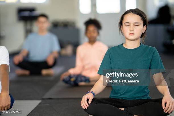 children meditating - achtsamkeit persönlichkeitseigenschaft stock-fotos und bilder