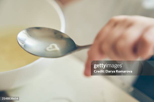 noodles in the shape of a heart in a spoon with broth. the concept of the love of noodles in children. - plastic bowls fotografías e imágenes de stock