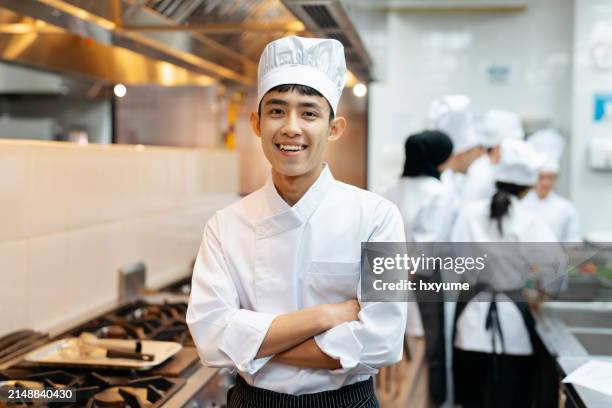 young and cheerful cooking class student in commercial kitchen - food and drink establishment stock pictures, royalty-free photos & images