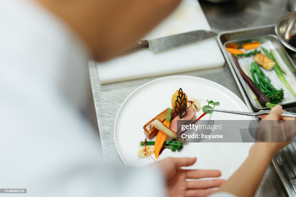 厨房でグルメ料理を作る若きシェフ