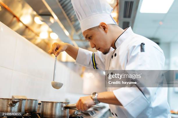 chef cooking soup in commercial kitchen - the original soup man stock pictures, royalty-free photos & images
