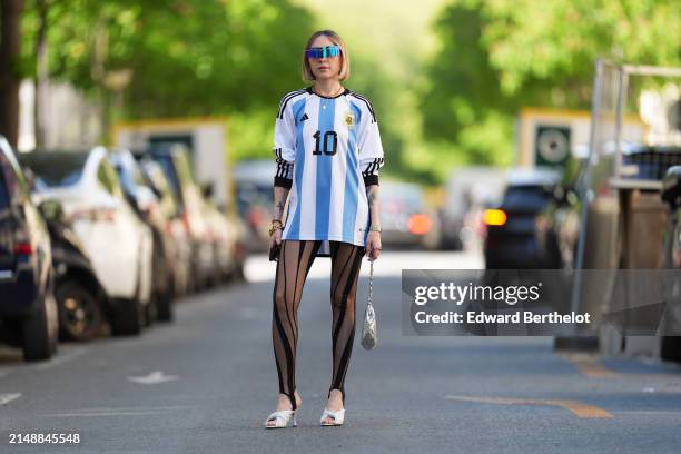 Emy Venturini wears sunglasses from Pierre Cardin, a Cartier watch, a blue and white striped Argentina soccer t-shirt from Adidas with printed "10"...
