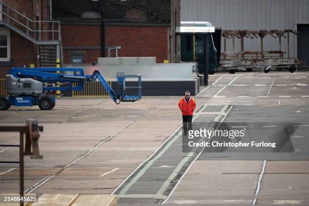 Workers walk through the Alstom train manufacturing facility and factory on April 16, 2024 in Derby, England. French manufacturer Alstom recently...
