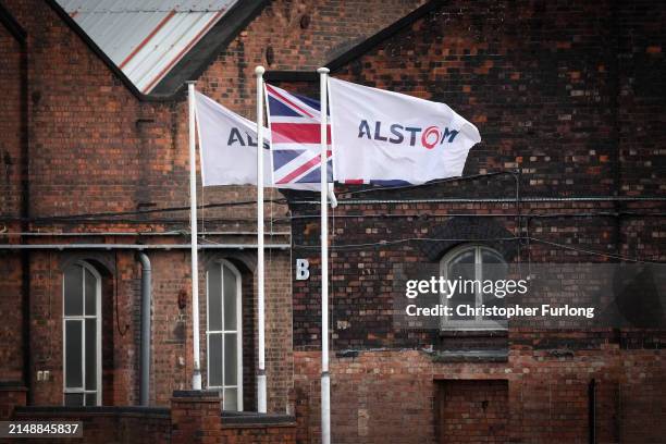 An Alstom company flags fly outside train manufacturing facility and factory on April 16, 2024 in Derby, England. French manufacturer Alstom recently...