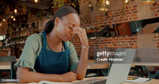 owner, black woman and tired with laptop in restaurant for menu development or startup business planning for cafe. girl, online and headache for long hours or financial pressure for profit sales. - overworked waitress stock pictures, royalty-free photos & images